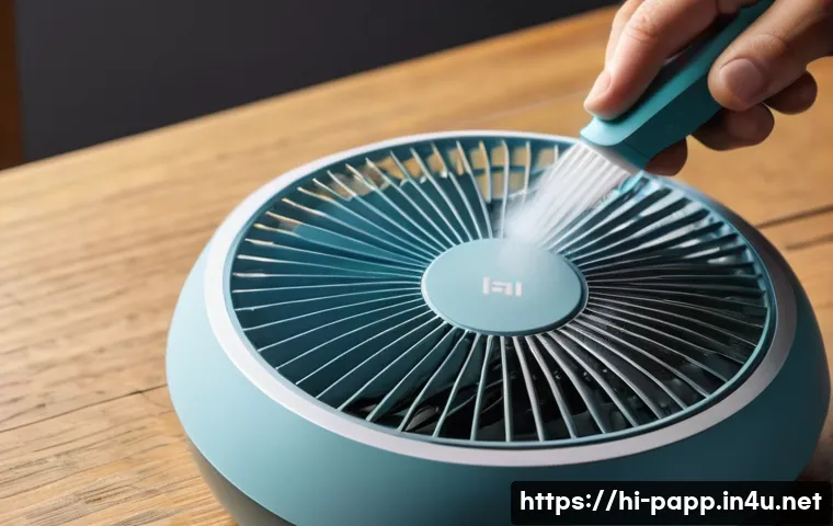USB 선풍기 소음 문제 해결 - A close-up scene of a person carefully cleaning a USB fan’s blades with a soft brush and dry cloth, ...
