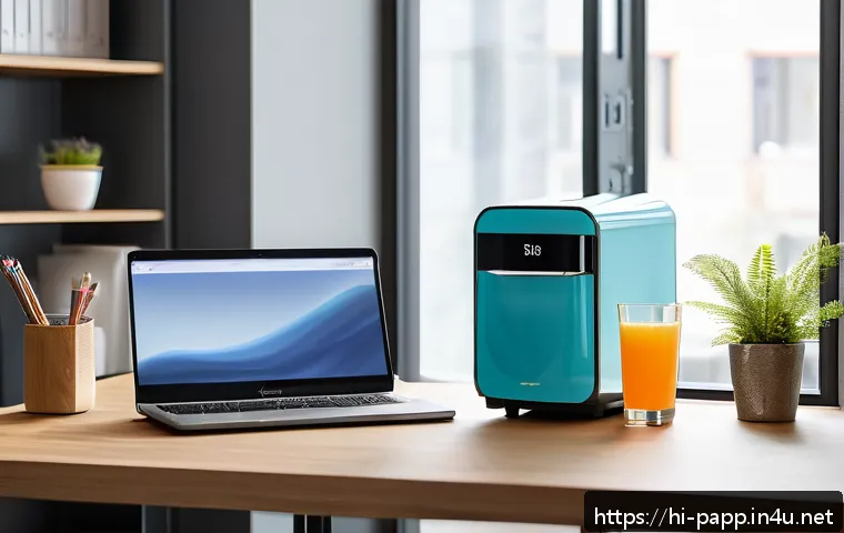 포터블 미니 냉장고 - A compact, sleek mini fridge placed on an office desk beside a laptop and stationery, with a glass d...